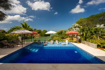 a swimming pool with chairs and umbrellas on a resort at Maravillosa Villa en Marina Baru enCartagena! in Isla Barú