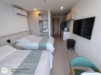 a hotel room with two beds and a flat screen tv at Aparta suite cerca al mar por vía Irotama in Santa Marta
