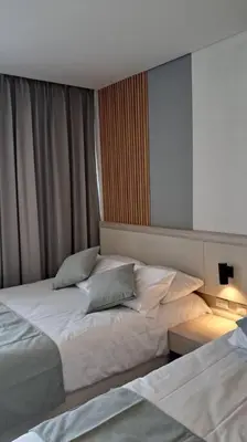 a hotel room with two beds and a mirror at Aparta suite cerca al mar por vía Irotama in Santa Marta