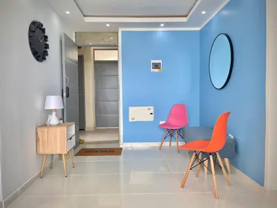 a room with two chairs and a blue wall at Apartamento con vista única cerca de la Uninorte in Puerto Colombia