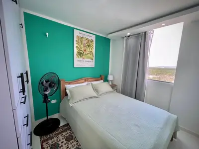 a bedroom with a bed and a green wall at Apartamento con vista única cerca de la Uninorte in Puerto Colombia