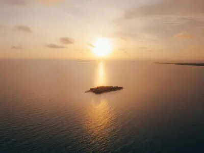 an island in the middle of the ocean with the sunset at Isla Corona in Baru