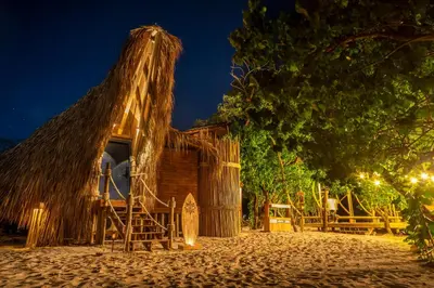 a small hut with a thatched roof at night at Isla Corona in Baru