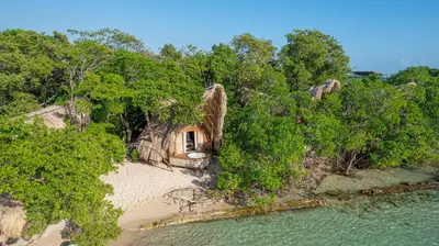 an aerial view of a small house on a beach at Isla Corona in Baru