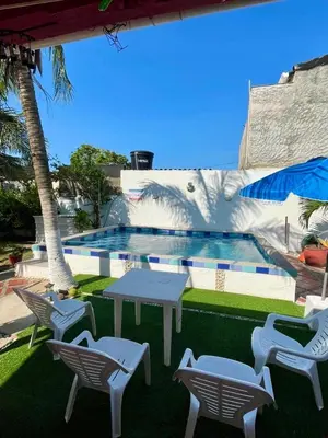 a pool with a table and chairs next to a building at Casa campestre Magyli in Puerto Salgar