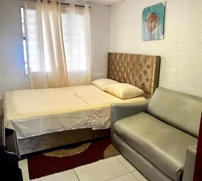 a small bedroom with a bed and a couch at Casa campestre Magyli in Puerto Salgar
