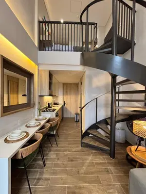 a living room with a spiral staircase and tables and chairs at THE LOFT 405 in San Basilio - La Matuna - Cartagena in Cartagena de Indias