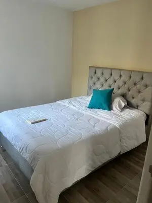 a bedroom with a large bed with a blue pillow at Margarita's apartment in Puerto Colombia