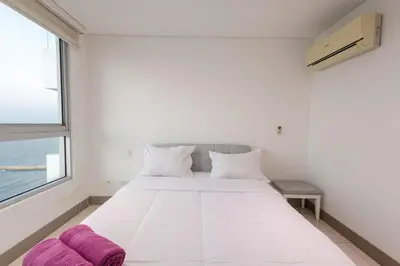 a bedroom with a large white bed with a window at Majestic apt with an ocean view Palmetto Beach in Cartagena de Indias