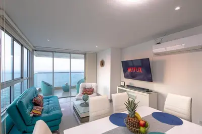a living room with a blue couch and a table at Majestic apt with an ocean view Palmetto Beach in Cartagena de Indias