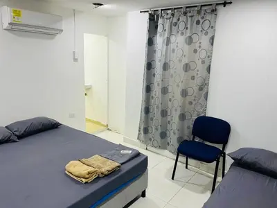 a bedroom with a bed and a chair in it at Habitación cerca a la playa 105 in Cartagena de Indias