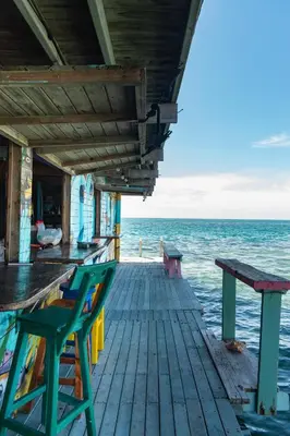 a dock with two chairs and a bench on the water at Casa Acuarimantima in Tintipan Island