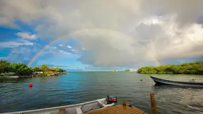 a rainbow over a body of water with a boat at Casa Acuarimantima in Tintipan Island