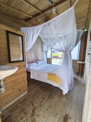 a bedroom with a bed with a mosquito net at Casa Acuarimantima in Tintipan Island