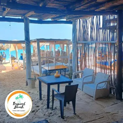 a patio with a table and chairs on the beach at Tropical Beach in Playa Blanca