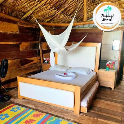 a bed with a hammock in a room at Tropical Beach in Playa Blanca