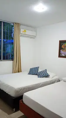 two beds in a room with a window at Apartamento con piscina in San Silvestre