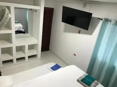 a room with a tv and a bed and a mirror at La Armonia in Cartagena de Indias