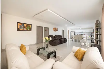 a white living room with white couches and a table at Casa con piscina cerca al aeropuerto in Malambo