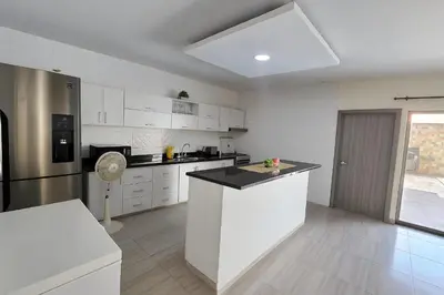 a kitchen with white cabinets and a white counter top at Casa con piscina cerca al aeropuerto in Malambo