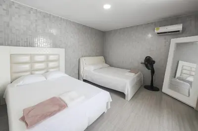a hotel room with two beds and a mirror at Casa con piscina cerca al aeropuerto in Malambo