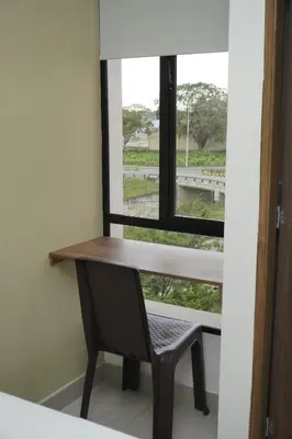 a desk and a chair in a room with a window at Hotel INdustrial in Sincelejo