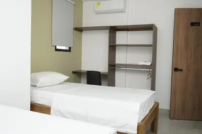 a bedroom with two beds and a book shelf at Hotel INdustrial in Sincelejo