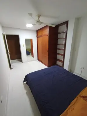 a bedroom with a blue bed and a closet at Apartamento al norte de Barranquilla in Barranquilla