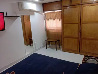 a bedroom with a bed and a chair and a closet at Apartamento al norte de Barranquilla in Barranquilla