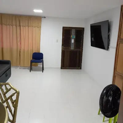a living room with a tv and a blue chair at Apartamento al norte de Barranquilla in Barranquilla