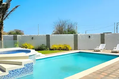 a swimming pool with two chairs and a fence at Casa de playa privada Sabanilla 4 cuadras del mar in Maizal