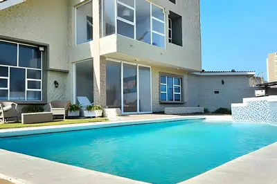 a swimming pool in front of a house at Casa de playa privada Sabanilla 4 cuadras del mar in Maizal