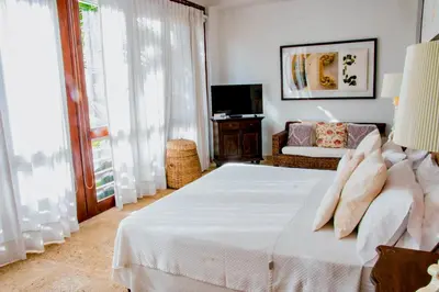 a bedroom with a white bed and a couch at 5 BR Villa inside of the walled city in Cartagena de Indias