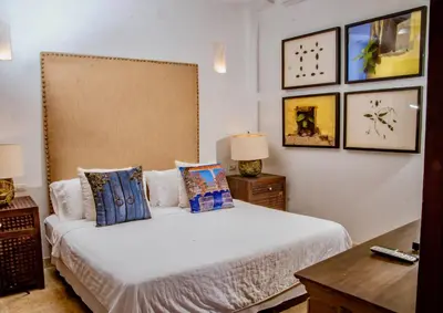 a bedroom with a bed with pillows on it at 5 BR Villa inside of the walled city in Cartagena de Indias