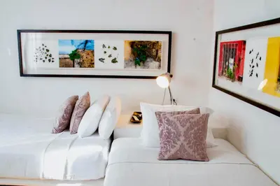 a bedroom with two beds and a picture on the wall at 5 BR Villa inside of the walled city in Cartagena de Indias