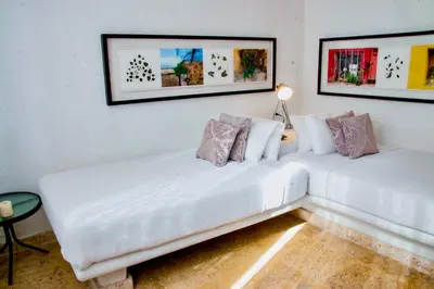 two white couches in a room with paintings on the wall at 5 BR Villa inside of the walled city in Cartagena de Indias