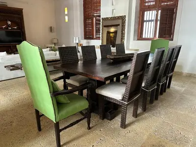 a dining room table and chairs with green chairs at 5 BR Villa inside of the walled city in Cartagena de Indias