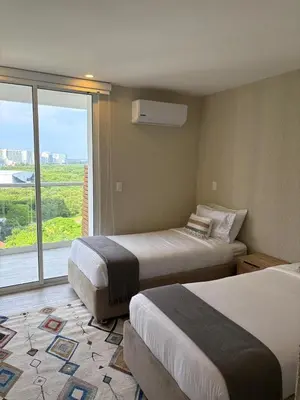 a hotel room with two beds and a large window at Como estar en casa! in Cartagena de Indias
