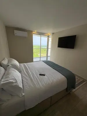 a bedroom with a large white bed with a window at Como estar en casa! in Cartagena de Indias