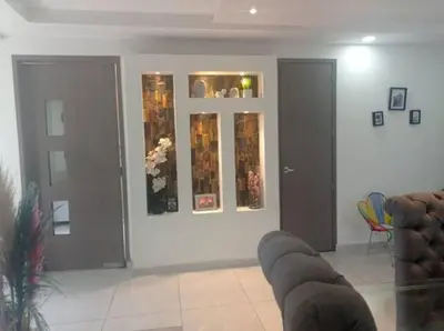 a living room with a couch and a wall with paintings at Melihouse in Barranquilla
