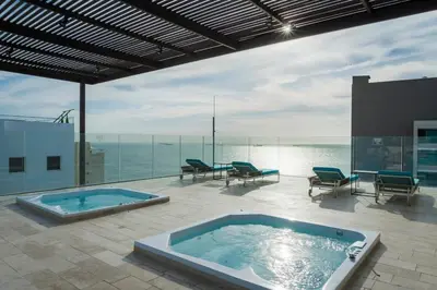 a hot tub on a patio with a view of the ocean at Apto de Lujo con Vista al Mar en Playa Bello Horizonte in Santa Marta