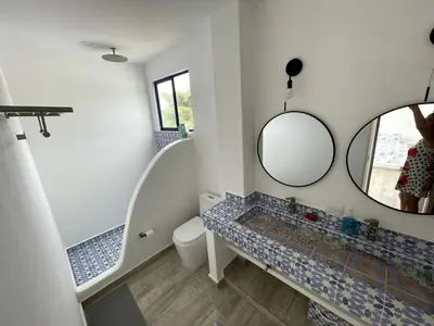 a bathroom with a toilet and a mirror at Shambala Beach House in San Bernardo del Viento
