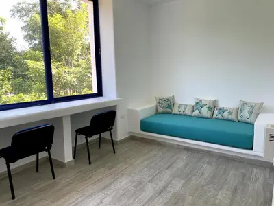a room with a couch and two chairs and a window at Shambala Beach House in San Bernardo del Viento