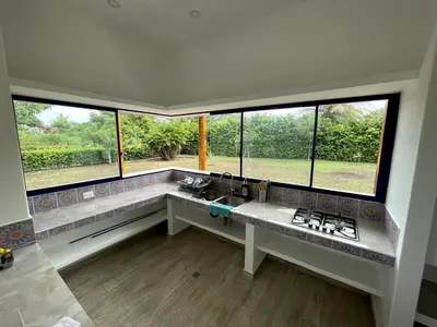 a kitchen with a counter with a sink and windows at Shambala Beach House in San Bernardo del Viento