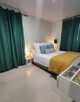 a bedroom with a bed with green curtains at Casa Plenitud Lux in Cartagena de Indias
