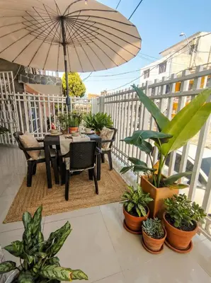 a table with an umbrella on a balcony with plants at Casa Plenitud Lux in Cartagena de Indias