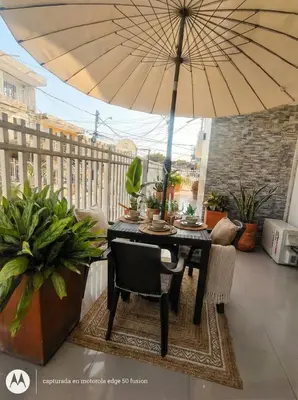 a table and chairs with an umbrella on a balcony at Casa Plenitud Lux in Cartagena de Indias