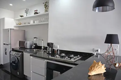 a kitchen with a stove top oven next to a refrigerator at Apartamento en cartagena - cristoforo piso 7 in Cartagena de Indias