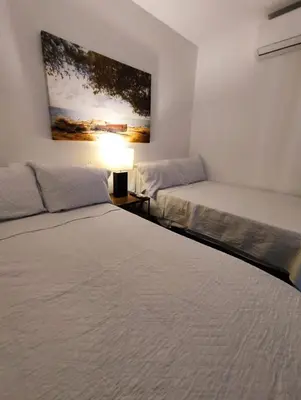 two beds in a room with a painting on the wall at Apartamento en cartagena - cristoforo piso 7 in Cartagena de Indias