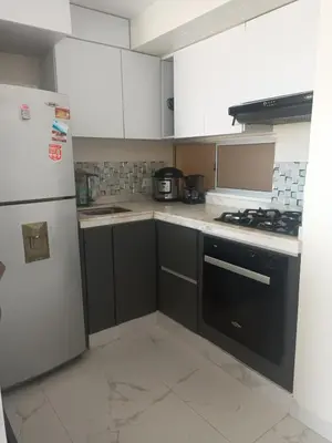 a kitchen with white cabinets and a black refrigerator at Alquiler Apartamento Amoblado in Barranquilla